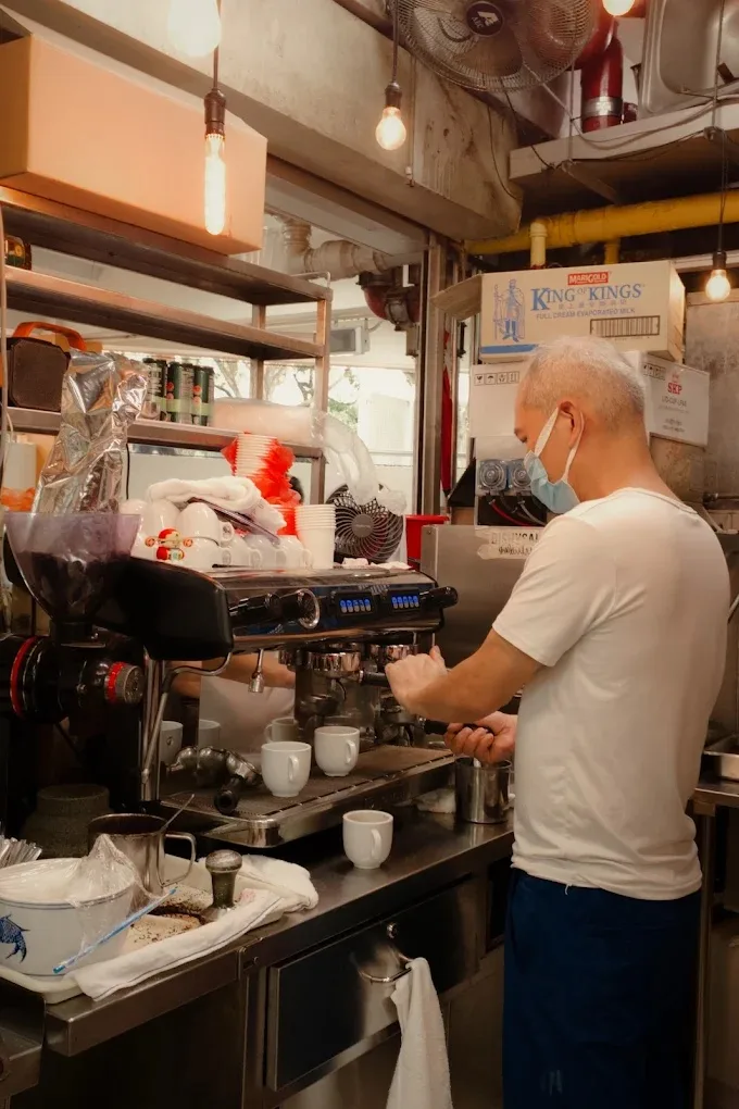 Inside the stall: grinder, espresso machine and stacked cups at #B1-49